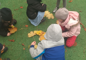 Dzieci układają liście w kształcie sukni